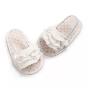 Detailed view of white baby girl ruffled sandals with gold polka dots