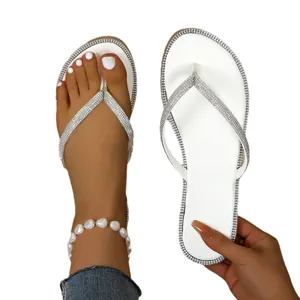 Elegant white flip flops with sparkling rhinestones for summer beach fashion.