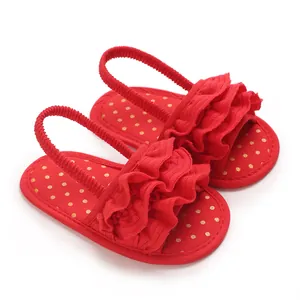 Close-up of red baby girl ruffle sandals with gold polka dots and soft elastic straps
