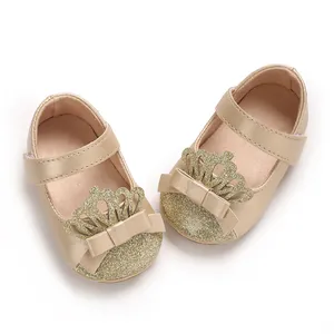 Detailansicht der goldenen Baby-Lauflernschuhe mit Krone und Schleifendekor