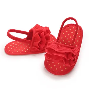 Close-up detail of red ruffled baby girl sandals featuring golden polka dot pattern insole