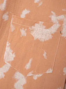 Macro detail of men's summer tie-dye shirt showing linen texture and pocket stitching.