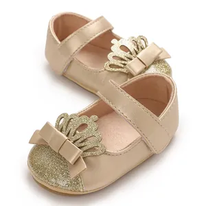 Detailansicht goldener Lauflernschuhe für Babys mit glitzernder Krone und Schleife