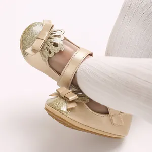 Detailansicht der goldenen Lauflernschuhe für Mädchen mit Glitzerkrone und Schleife.