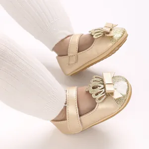 Nahaufnahme goldener Baby-Lauflernschuhe mit glitzernder Kappe und elegantem Kronen-Dekor.