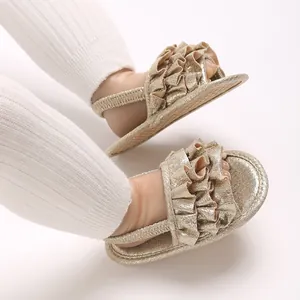 Close-up view of gold glittery baby sandals featuring elegant ruffle decorative straps