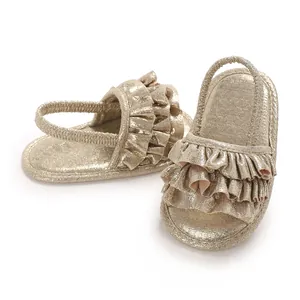 Detailed view of shiny gold ruffled baby girl sandals with soft sole and elastic strap