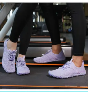 Dettaglio scarpe da scoglio viola in mesh indossate su un tapis roulant per il fitness.
