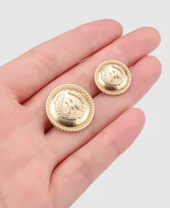 Detailed macro shot of golden metal buttons with embossed M and wreath pattern