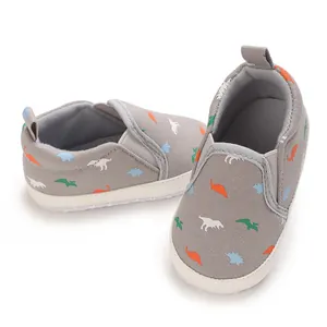 Close-up of grey baby slip-on shoes with colorful dinosaur patterns and soft soles