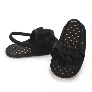 Detail of baby girl soft sole black sandals with gold polka dots and ruffles