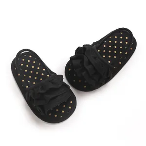 High quality top view of black baby girl sandals with gold polka dots and ruffles