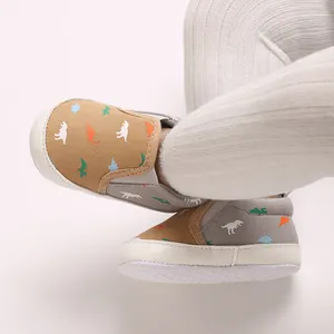 Close-up detail of soft-sole infant walking shoes featuring colorful dinosaur prints