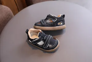 Macro view of retro black baby sandals with breathable hollow design and rubber soles