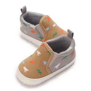 Detail of baby walking shoes with dinosaur print and soft canvas sole.