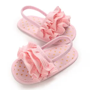 Detailed view of pink baby girl sandals with ruffles and golden polka dot insoles