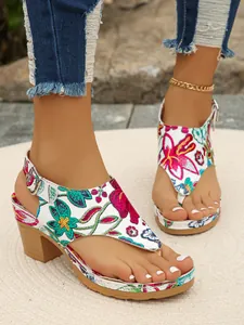 Nahaufnahme von sommerlichen Zehentrenner-Sandalen mit Boho-Stickerei und Blockabsatz.