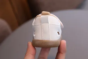 Detailed view of white baby leather shoe heel with non-slip brown rubber sole texture