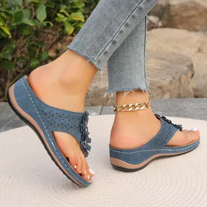 Vue latérale de sandales compensées bleues avec décor floral et détails ajourés
