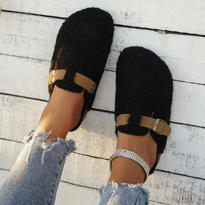 Detail view of black fuzzy sherpa clogs with adjustable buckle strap and cozy lining.
