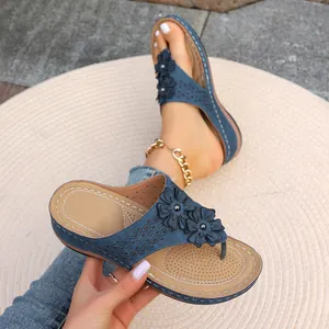 Vue détaillée des sandales compensées bleues avec motifs floraux évidés et fleurs.