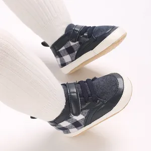Gros plan de chaussures bébé antidérapantes bleues et à carreaux pour premiers pas