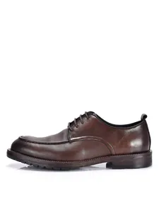 Vista lateral de un zapato de vestir de cuero marrón con cordones y estilo británico.