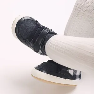 Gros plan de chaussures de marche pour bébé à carreaux bleu marine avec semelles blanches