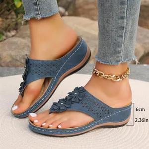 Détail des tongs compensées bleues avec fleurs et mesure de la hauteur de talon