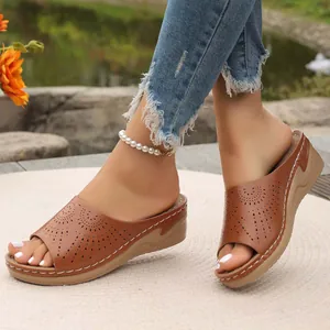 Eleganti sandali con zeppa marroni con motivi traforati e cuciture bianche