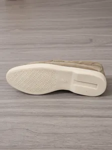 Detailansicht der cremefarbenen rutschfesten Außensohle eines khakifarbenen Wildleder-Loafers