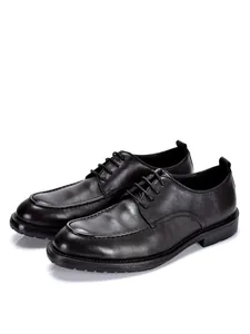 Vista detallada de zapatos Oxford de cuero negro para hombre con cordones clásicos.