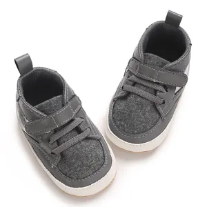 Chaussures de marche grises pour bébé avec semelle souple et bande velcro.
