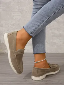 Detailansicht von khakifarbenen Wildleder-Loafers mit weißen weichen Sohlen