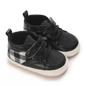 Gros plan détaillé de chaussures de marche pour bébé à carreaux noirs et blancs
