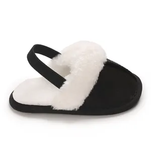 Primo piano di accoglienti pantofole per neonati in peluche bianco e nero con cinturino