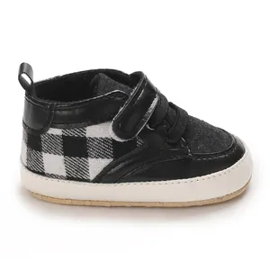 Vue détaillée latérale de chaussures de marche pour bébé à carreaux noir et blanc.