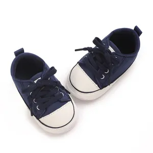 Detail view of navy blue baby canvas shoes with white rubber toes and navy laces