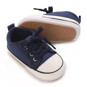 Detailed macro view showing navy blue canvas baby shoes with non-slip textured rubber soles