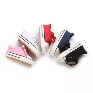 Collection of colorful infant canvas sneakers in pink, white, red, navy, and black