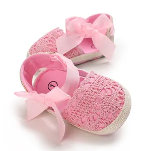 Detailed view of pink lace baby girl sandals featuring a soft sole and ribbon bow.