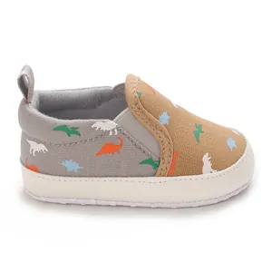 Close-up view of soft-sole infant canvas walking shoe with colorful dinosaur pattern