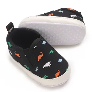 Close-up of black baby walking shoes with dinosaur pattern and anti-slip sole.