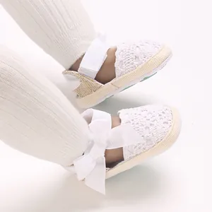 Close-up view of white breathable lace baby girl sandals with decorative bow detail