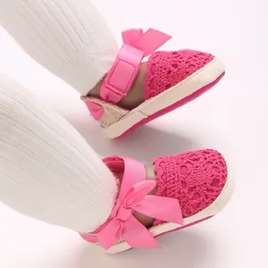 Detailed view of pink newborn baby girl sandals with lace crochet and satin bow