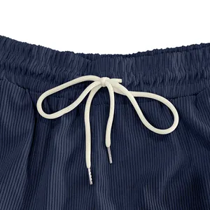 Macro close-up of navy blue corduroy shorts waistband with white adjustable drawstring.
