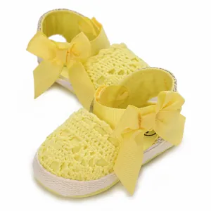Soft yellow crochet baby sandals with decorative ribbons and breathable mesh design.
