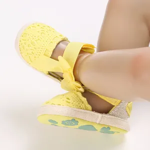 Close-up of yellow lace baby girl sandals with breathable cloth sole