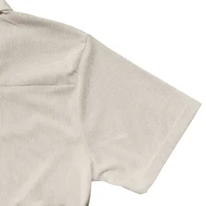 Close-up detail of the ribbed fabric and sleeve of a beige men's short sleeve Polo shirt