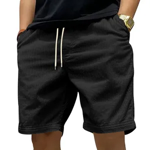 Detail van zwarte corduroy strandshorts met fijne gestreepte textuur en trekkoord